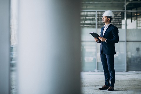 Handsome business man engineer in hard hat in a building